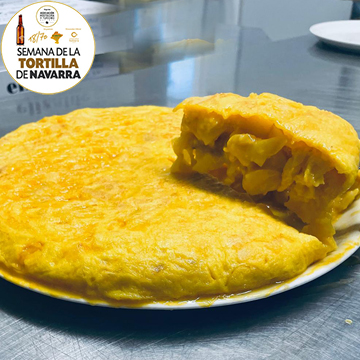 Tortilla completa con una porción de tortilla de patata tradicional en la parte superior de la Cafeteria Elizalde de Pamplona